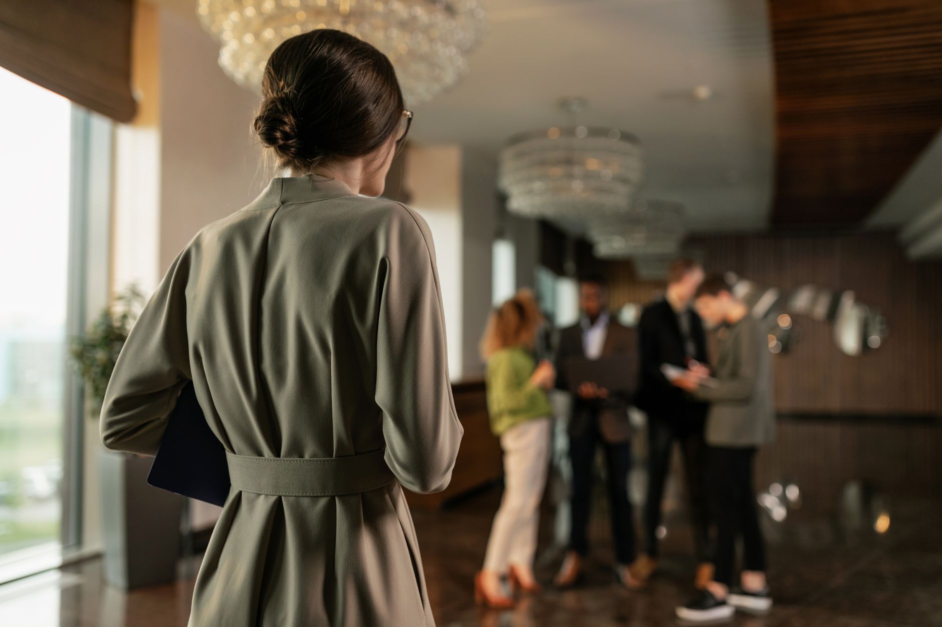 woman in gray coat standing in front of people